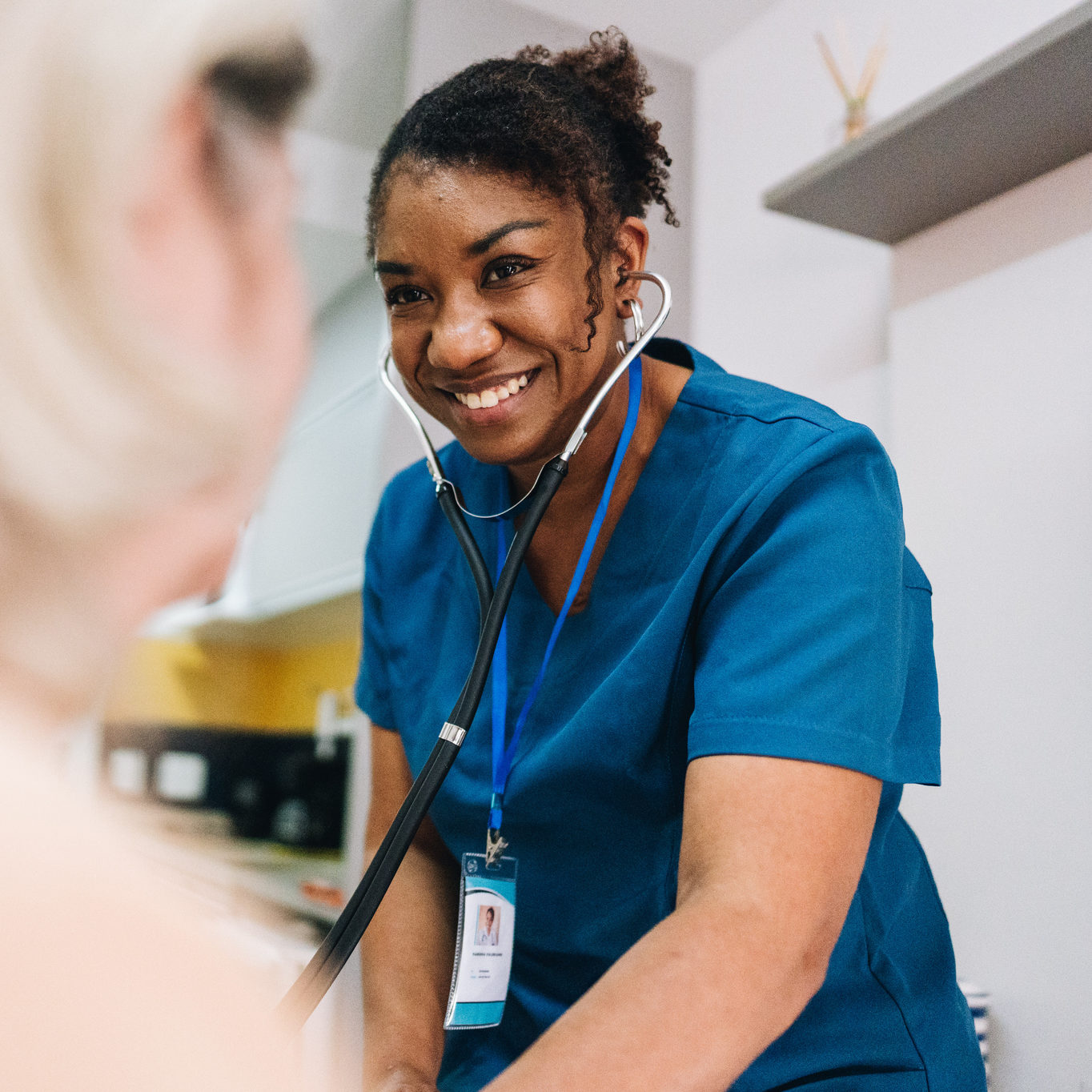 Nurse taking blood pressure of a senior woman patient at home